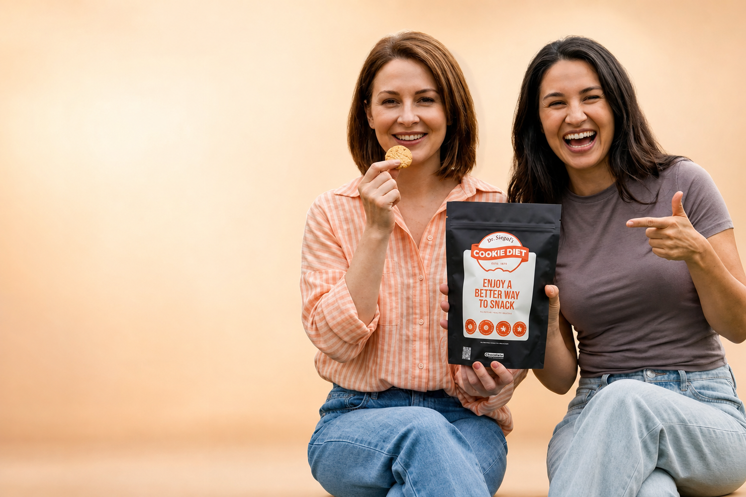 Two women smiling while holding Dr. Siegal’s Cookie Diet cookies.